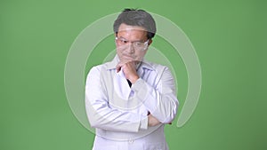 Mature Japanese man doctor wearing protective glasses