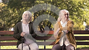 Mature ladies sitting separately on bench in park, friends argued and quarreled photo