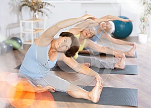 Mature lady performs pose Parivritta janu shirshasana