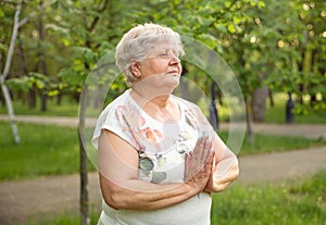 Mature lady relaxing in nature. Woman meditating. Healthy lifestyle