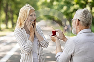 Mature Love. Romantic Senior Gentleman Making Proposal To Happy Excited Lady Outdoors