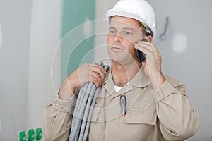 mature male builder talking on mobile phone