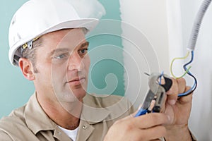 mature male builder using cable cutters