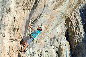 Mature male Climber making risky Move on dangerous Rock