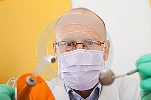 Dentist holding instruments, looking down