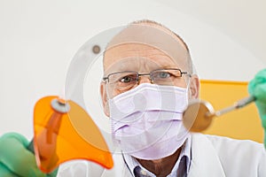 Dentist holding instruments, looking down