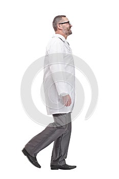 Mature male doctor striding forward. isolated on a white background.