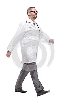 Mature male doctor striding forward. isolated on a white background.