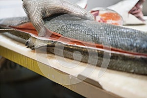 Mature male fishmonger cutting fish on table