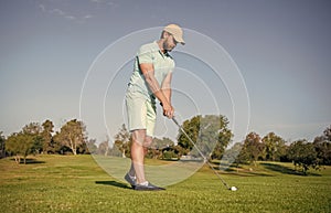 mature male golf player on professional course with green grass, golf course