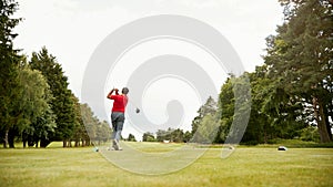 Mature Male Golfer Hitting Tee Shot Along Fairway With Driver