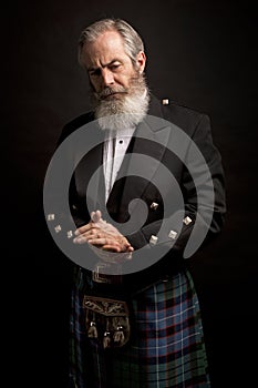 Mature male model wearing kilt with grey hairstyle and beard