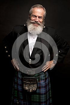 Mature male model wearing kilt with grey hairstyle and beard