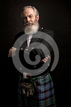 Mature male model wearing kilt with grey hairstyle and beard photo