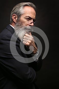 Mature male model wearing suit with grey hairstyle and beard