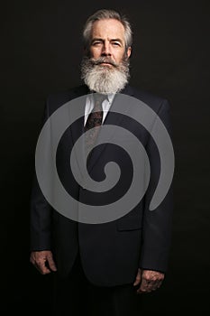 Mature male model wearing suit with grey hairstyle and beard