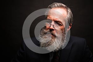 Mature male model wearing suit with grey hairstyle and beard