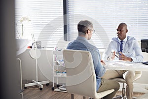 Mature Male Patient In Consultation With Doctor In Office