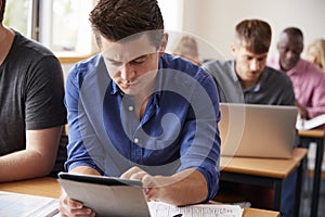 Mature Male Student With Digital Tablet In Adult Education Class