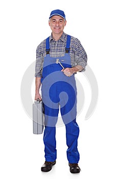 Mature male technician holding worktool