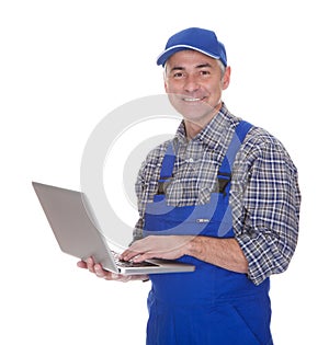 Mature male technician using laptop