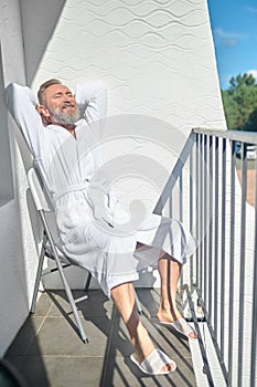 Mature male vacationer sunbathing in the morning