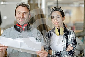 mature male worker with young female apprentice in workplace photo