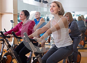 Mature males and females on exercise bikes in the gym