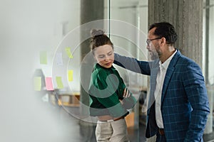 Mature man abusing his younger colleague, concept of harassment at workplace.