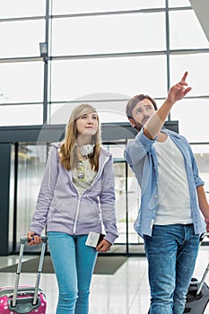 Mature man arriving with his daughter in airport looking for their pick up