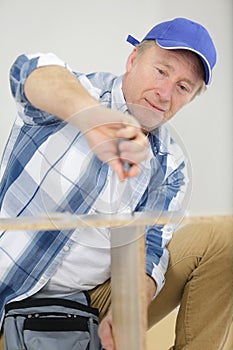Mature man assembling bed in new home