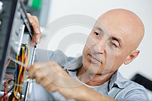 mature man assembling desktop computer photo