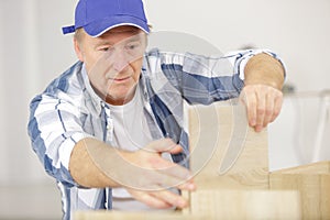 mature man assembling wooden furniture