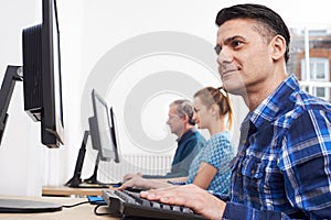 Mature Man Attending Computer Class In Front Of Screen