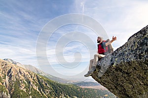 Mature man with backpack hiking in mountains in autumn, resting.