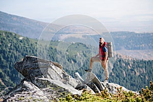 Mature man with backpack hiking in mountains in summer.