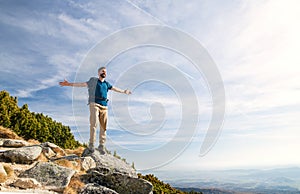 Mature man with backpack hiking in mountains in summer.