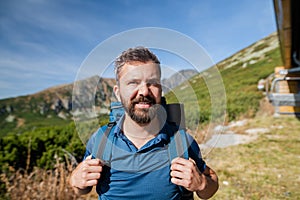 Zralý muž s batohem turistika v horách v létě.