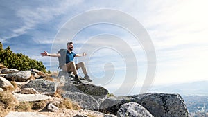 Mature man with backpack hiking in mountains in summer.