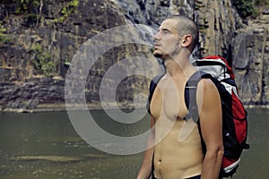 Mature man with backpack at waterfall pongour