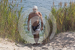Mature man in a baseball cap and bathing shorts