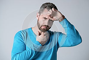 mature man with beard has heacache suffer from headahce on grey background, malaise