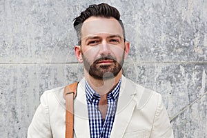 Mature man with beard standing against wall