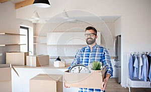 Mature man with box moving in new unfurnished house.