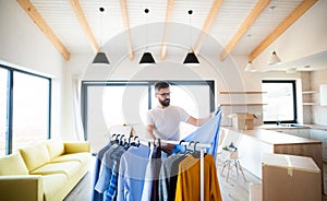 A mature man with boxes moving in new unfurnished house.