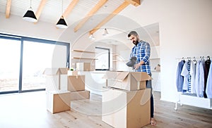 Mature man with boxes moving in new unfurnished house, unpacking.