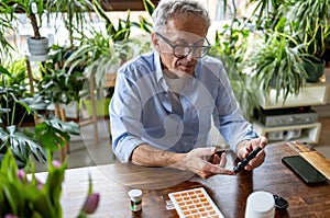 Mature man checking his blood sugar level