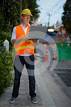 Mature man construction worker at the construction site in the c