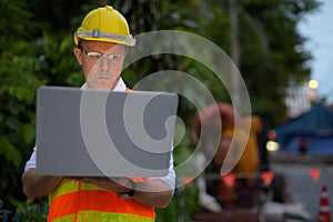 Mature man construction worker at the construction site in the c
