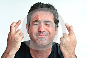 Mature man with crossed fingers hoping for luck photo